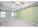 Spacious main bedroom featuring a tray ceiling, a fan, and natural light from two windows at 404 Straywhite Ave, Apex, NC 27539