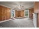 Spacious bedroom featuring classic wood paneling, carpet, and a ceiling fan at 421 E Morehead St, Burlington, NC 27215