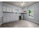 Kitchen features white cabinets, gray laminate floors, and good natural light at 421 E Morehead St, Burlington, NC 27215