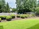 Landscaped backyard featuring a fire pit area with Adirondack chairs and a wooden fence at 4562 Brighton Ridge Dr, Apex, NC 27539