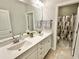 Well-lit bathroom with double vanity, a large mirror, and a separate shower with a patterned curtain at 4562 Brighton Ridge Dr, Apex, NC 27539