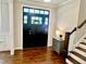 Inviting entryway with a dark wood front door, hardwood floors, and a staircase at 4562 Brighton Ridge Dr, Apex, NC 27539