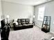 Neutral living room featuring a large window with a modern leather sofa and stylish decorative accents at 4562 Brighton Ridge Dr, Apex, NC 27539