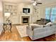 Cozy living room with a fireplace, built-in shelving, a ceiling fan, and hardwood floors at 4562 Brighton Ridge Dr, Apex, NC 27539