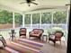 Cozy screened-in porch featuring comfortable seating and a colorful rug, perfect for outdoor relaxation and entertaining at 4562 Brighton Ridge Dr, Apex, NC 27539