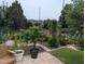 Lush backyard featuring a stone patio, potted plants, flowering plants and a variety of trees and greenery at 461 Cedar Pond Ct, Knightdale, NC 27545