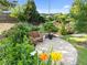 Lush backyard garden featuring a stone patio, bench, and diverse plants and flowers at 461 Cedar Pond Ct, Knightdale, NC 27545