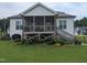 Backyard featuring a screened porch, steps to the ground, colorful garden beds and a spacious grassy yard at 461 Cedar Pond Ct, Knightdale, NC 27545
