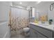 Clean bathroom with floral shower curtain, white vanity, and neutral decor at 461 Cedar Pond Ct, Knightdale, NC 27545