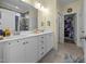 Bright bathroom featuring double sinks, white cabinetry, and a walk-in closet for storage and organization at 461 Cedar Pond Ct, Knightdale, NC 27545