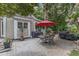 Beautiful backyard patio featuring a red umbrella, outdoor dining set, grill, and lush landscaping at 4620 Gomar Ln, Fuquay Varina, NC 27526