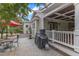 Outdoor brick patio featuring a grill, dining set, and covered porch with hanging lights for evening relaxation at 4620 Gomar Ln, Fuquay Varina, NC 27526