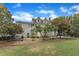 Expansive backyard featuring lush landscaping, mature trees, and a charming two-story home with a patio area for outdoor enjoyment at 4620 Gomar Ln, Fuquay Varina, NC 27526