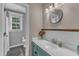 Bathroom featuring a turquoise vanity with white subway tile backsplash, and a round mirror at 4620 Gomar Ln, Fuquay Varina, NC 27526