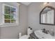 Powder room with stylish accents, featuring a decorative mirror and view to the outdoors at 4620 Gomar Ln, Fuquay Varina, NC 27526