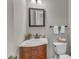 Traditional half bathroom featuring a wooden vanity, marble countertop and decorative mirror at 4620 Gomar Ln, Fuquay Varina, NC 27526