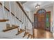 Elegant foyer with hardwood floors and staircase, showcasing a grand wooden front door at 4620 Gomar Ln, Fuquay Varina, NC 27526