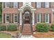 Elegant front entrance with brick steps, decorative columns, and manicured landscaping at 4620 Gomar Ln, Fuquay Varina, NC 27526