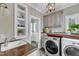 Well-appointed laundry room with modern appliances, sink, countertop, and built-in shelving at 4620 Gomar Ln, Fuquay Varina, NC 27526