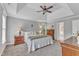 Main bedroom with a tray ceiling, carpet floors, and windows overlooking the yard at 4620 Gomar Ln, Fuquay Varina, NC 27526