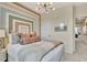 Well-lit bedroom showcasing modern lighting, textured headboard, and neutral color palette at 5028 Jowetts Walk Dr # 24, Cary, NC 27519