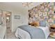Bedroom featuring a geometric wallpaper accent wall, modern chandelier, and soft, natural lighting at 5028 Jowetts Walk Dr # 24, Cary, NC 27519