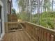View of the wooden deck with a wood railing overlooking a wooded area at 5028 Jowetts Walk Dr # 24, Cary, NC 27519