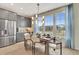 Dining area featuring a wooden table, modern chandelier, large windows for natural light, and adjacent kitchen amenities at 5028 Jowetts Walk Dr # 24, Cary, NC 27519