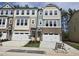 Charming townhome exterior features brick accents, white garage doors and manicured landscaping at 5028 Jowetts Walk Dr # 24, Cary, NC 27519