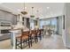 Modern kitchen with gray cabinets, stainless steel appliances, pendant lighting, island with bar seating and dining area at 5028 Jowetts Walk Dr # 24, Cary, NC 27519