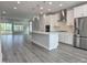 Open-concept kitchen features an island, stainless steel appliances, and hardwood floors at 5028 Jowetts Walk Dr # 24, Cary, NC 27519