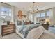 Spacious primary bedroom with three large windows, decorative lighting and floral accents at 5028 Jowetts Walk Dr # 24, Cary, NC 27519