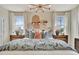 Beautiful primary bedroom with three large windows, decorative lighting, and bedside tables at 5028 Jowetts Walk Dr # 24, Cary, NC 27519