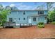 The home's backyard features a deck, a large yard with beautiful trees, and neutral siding at 5800 Heatherbrook Cir, Raleigh, NC 27612