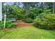 Lush backyard featuring a deck, mature trees, and manicured landscaping providing a tranquil retreat at 5800 Heatherbrook Cir, Raleigh, NC 27612