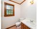 Cozy bathroom featuring a window, toilet, and vanity with a sink at 5800 Heatherbrook Cir, Raleigh, NC 27612