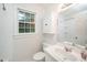 Bright bathroom features a vanity with a white sink, toilet, a built-in cabinet, and a window at 5800 Heatherbrook Cir, Raleigh, NC 27612