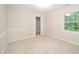 Carpeted bedroom with natural light, trimmed walls, and an adjacent closet space at 5800 Heatherbrook Cir, Raleigh, NC 27612