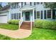 Charming blue two-story home with a brick front porch, lush landscaping, and a two-car garage at 5800 Heatherbrook Cir, Raleigh, NC 27612