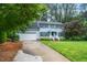 Charming blue two-story home with white trim, well-manicured lawn, and a spacious driveway at 5800 Heatherbrook Cir, Raleigh, NC 27612