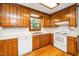 Well-lit kitchen showcasing matching white appliances and wood cabinets with bright countertop space at 5800 Heatherbrook Cir, Raleigh, NC 27612
