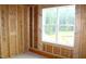New construction with exposed wood studs and a large window overlooking trees at 5900 Tranquil Cv, Youngsville, NC 27596