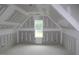 Upstairs bonus room, featuring high ceilings and natural light from the window at 5900 Tranquil Cv, Youngsville, NC 27596