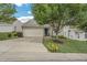A well-maintained home featuring a blue front door, attached garage, concrete driveway and mature landscaping at 6 Newgate Ct, Durham, NC 27713