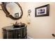 Charming half bath featuring a black vanity with a unique copper sink, decorative mirror, and a framed print at 6035 Sentinel Dr, Raleigh, NC 27609
