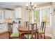 Cozy dining area featuring white cabinets, a window with bright natural light, and hardwood floors at 6035 Sentinel Dr, Raleigh, NC 27609