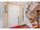 Inviting entryway with hardwood floors, white staircase, and natural light streaming through a window at 6035 Sentinel Dr, Raleigh, NC 27609