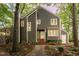 Two-story home featuring gray siding, a welcoming front entrance, and nestled in mature trees at 6035 Sentinel Dr, Raleigh, NC 27609