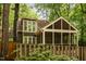 View of the home's back exterior with a screened porch, wooden fence, and lush green foliage at 6035 Sentinel Dr, Raleigh, NC 27609