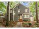 Charming two-story home with gray siding, white trim, and a welcoming front porch surrounded by mature trees at 6035 Sentinel Dr, Raleigh, NC 27609